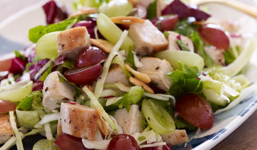 crispy chopped chicken with grapes on top of lettuce