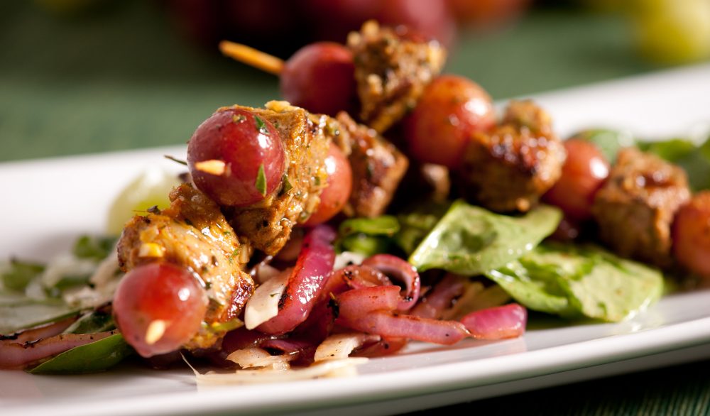 Grilled Spiced Pork and Grape Kebabs on a white plate